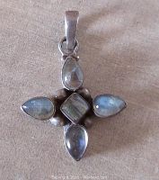 Front view of a vintage sterling silver pendant with five labradorite stones set in a cross pattern, including a square center stone and four teardrop stones on the arms.