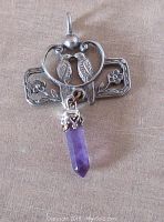 Front view of pewter finish openwork pendant showing two birds and floral details with dangling amethyst quartz crystal point