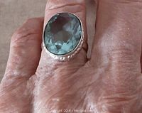 Ring on finger showing size and aqua quartz stone color.