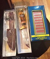 Photo showing the Timber Rattler knife with its sheath and the honing stone in original boxes.