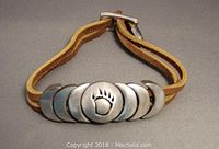 Close-up of the pewter centerpiece with bear claw on leather band showing design details and clasp.