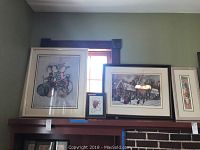 Three framed art pieces arranged on mantle including two numbered and signed prints and a smaller detailed print in the middle. Sizes from approx 9x14 to 36x31 inches.