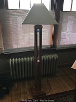 Full front view of Stickley floor lamp showing wood frame and beige fabric shade