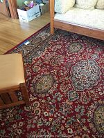 Full view of wool area rug under couch and ottoman