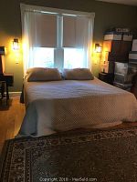Full view of beige king size bedspread on bed with two matching pillow shams in a bedroom setup.
