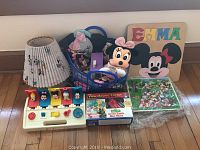 Overview of Disney collection with lamp, Sesame Street View Master, puzzles, wooden Disney art and plush toys