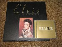 Black box with title 'Elvis His Life and Music' and a photo of Elvis Presley on front, 1 CD case with gold cover shown