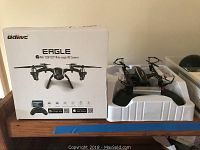 Udirnc Eagle drone with original box and drone in plastic tray on wooden surface.
