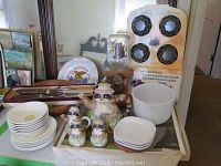 Kitchenware group with hand painted raccoon ceramic teapot, creamer, salt and pepper shakers, matching bowls and plates, painted wooden bowl, carving set, and ice cream molds.