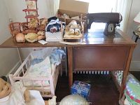 Photo showing sewing machine on sewing table with various doll items around.