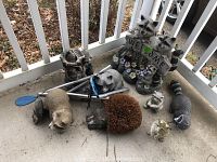 All items grouped together showing raccoon boot scraper brush, figurines, wind chimes, and the welcome sign