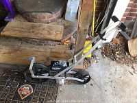 Side view of Earthway Seeder showing aluminum frame, black hopper, and wheels.