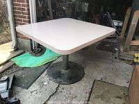 View of the table top showing light-colored laminate surface and some stains.