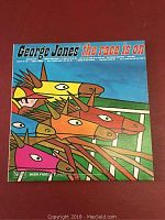 Front cover of George Jones vinyl record titled 'The Race Is On' featuring colorful stylized horse race artwork.