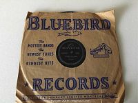 Vintage Elvis Presley 78 RPM vinyl record in original Bluebird Records paper sleeve. Sleeve shows creases and age wear.