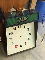 Vintage 7up advertising clock showing clock face and 7up illuminated logo panel.