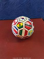 Soccer ball featuring multiple international flags and country names such as Canada, South Korea, Ghana, Trinidad and Tobago, Italy, Sweden.