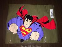 Superman wall decal laid flat showing design and colors clearly on a brown surface.