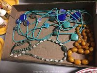 Overview of all four necklaces laid in box showing colors and bead types