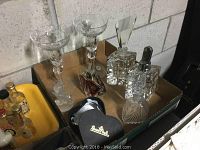 Four assorted glass perfume bottles with uniquely shaped stoppers and a black heart-shaped Rosenthal trinket dish with gold mark.