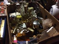 Overview of assorted perfume bottles in a cardboard box showing varied shapes and colors