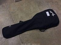 Black Fender gig bag case laid out flat on concrete floor