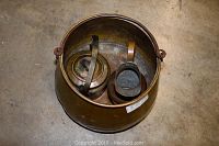 Overhead photo of large brass cauldron containing small brass kettle and pitcher showing the full lot and relative sizes