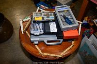 Overview of the entire lot on a round table including various tool cases, wooden ruler, and a level.