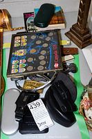 Photo displaying a Canada 125 Coin Set displayed in a folder with colorful provincial flags and coins, along with various pouches and cases scattered around.