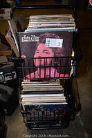 Two-tier black metal crate filled with vinyl LP records; front record is John Prine - Diamonds In The Rough