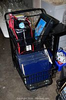 Photo of black metal cart containing LPs, CDs, and Pink Floyd book.