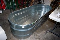 Full view of oval galvanized stock tank trough with ribbed sides