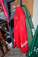 Two patio umbrellas hung, one red with Grand Marnier branding, one green.