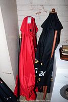 Two patio umbrellas folded and leaning against a wall.