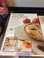Photo of the marble pastry board packaging showing the product and its dimensions.