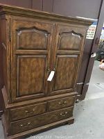 Front view of the Drexel armoire showing double doors and three lower drawers.