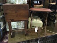 Wooden TV trays stacked on and next to a folding stand, showing overall shape and color.