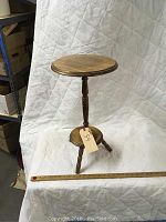 Full view of the small turned wood plant stand showing its structure and legs.