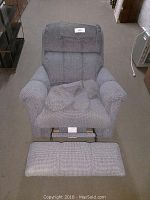 Front view of blue La-Z-Boy recliner chair with extended footrest showing textured fabric and worn condition.