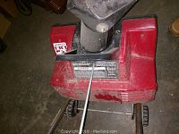 Photo of the snow thrower showing the top and chute areas with labels and build.