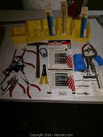 Wide shot showing various hand tools, pliers, clamps, hammer, and saw blades including unopened Black & Decker blade packages.