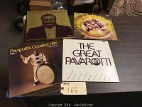 Four Pavarotti vinyl albums displayed side-by-side on a table including one signed copy.