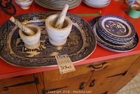 Photo showing the full lot with blue willow platter, plates stacked in the back, and two marble mortar and pestles on top of the platter.