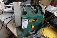 Front angle view of the green Craftex wet grinder showing the power switch, grinding wheel, and adjustable tool rests.