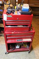Full view of red two-piece rolling metal tool chest on casters