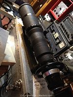 Long shot of black lens with focus and mount rings atop equipment