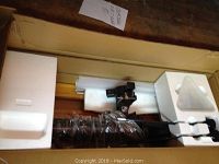 Black telescope optical tube and mounting bracket seated in white Styrofoam inside original box