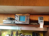 Oscilloscope BB-5702 on shelf with reels and a cylindrical container nearby