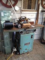 Full view of cabinet-style planer with detached motors and parts on tabletop