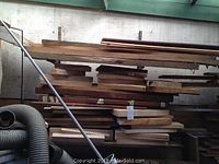 Multiple wood boards stacked on metal shelving